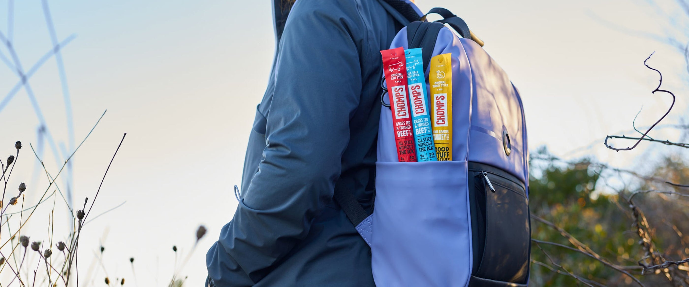 A person hiking with a backpack full of Chomps