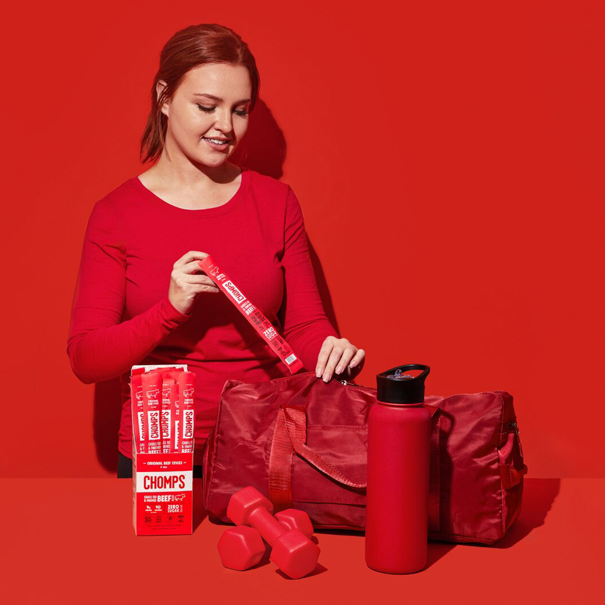 A woman putting an Original Beef Chomps in a gym bag