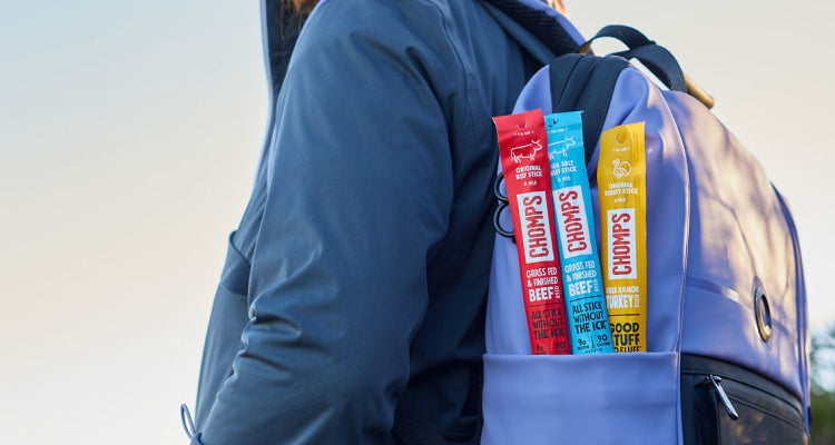 A person hiking with a backpack full of Chomps